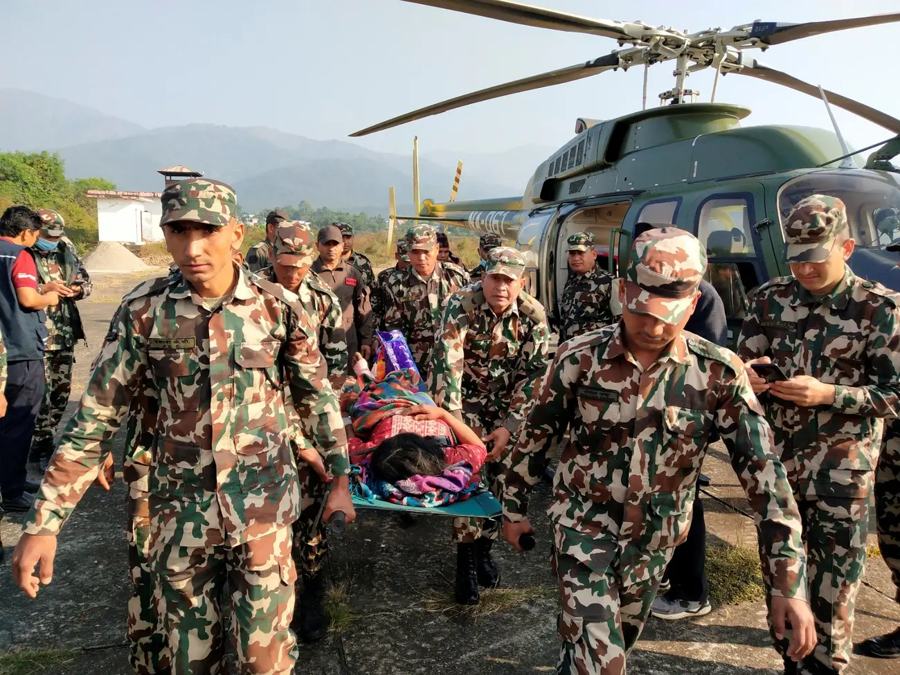 Army personnel carry an injured person on a stretcher after an earthquake in Jajarkot